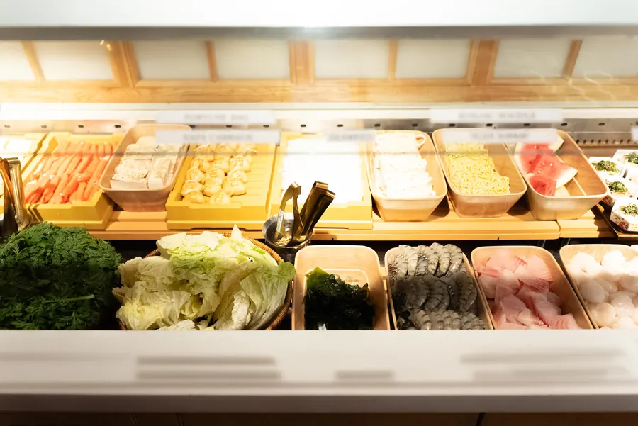 Trays of vegetables, tofu and seafood at the self-serve bar